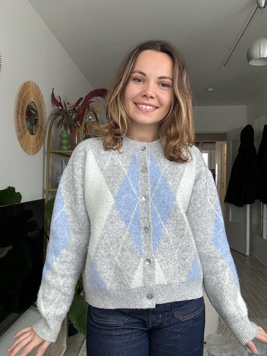Femme portant le cardigan Céleste gris et bleu à motif losanges en maille douce, style chic et décontracté