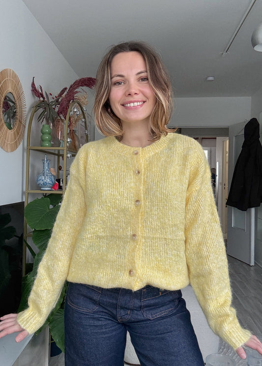 Femme portant le pull Paloma jaune en maille douce avec boutons décoratifs, style chic et décontracté