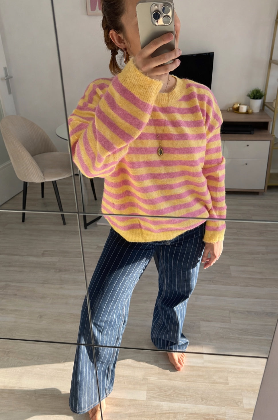 Femme portant un pull rayé rose et jaune en maille douce avec un jean, style chic et décontracté